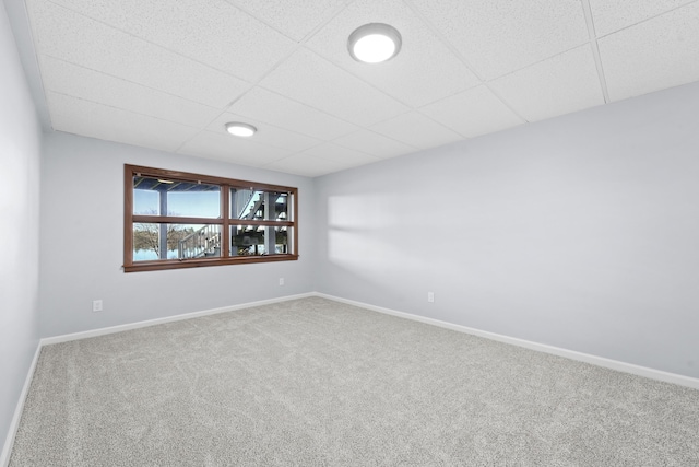 unfurnished room featuring a paneled ceiling, baseboards, and carpet floors