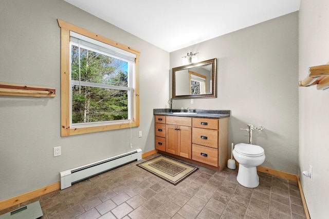 bathroom featuring vanity, toilet, baseboards, and a baseboard radiator