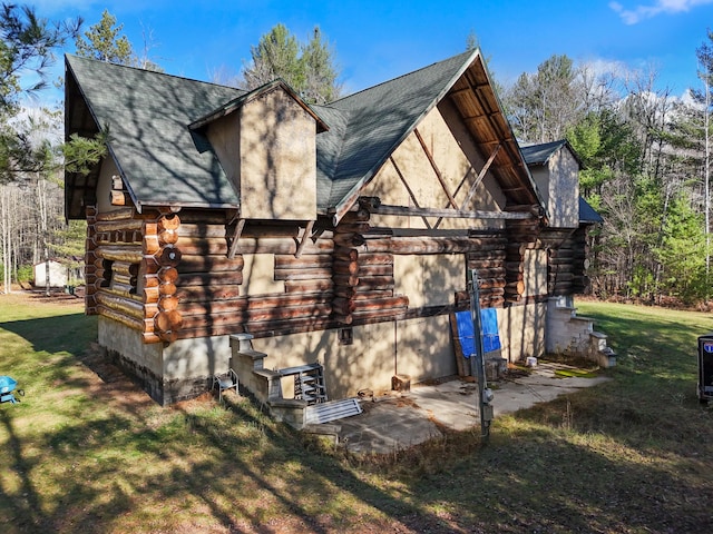 view of home's exterior with log siding and a yard