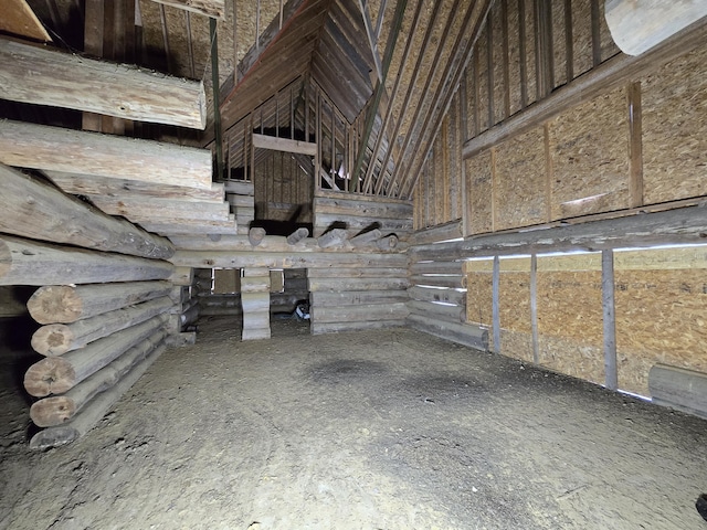 interior space with lofted ceiling and log walls