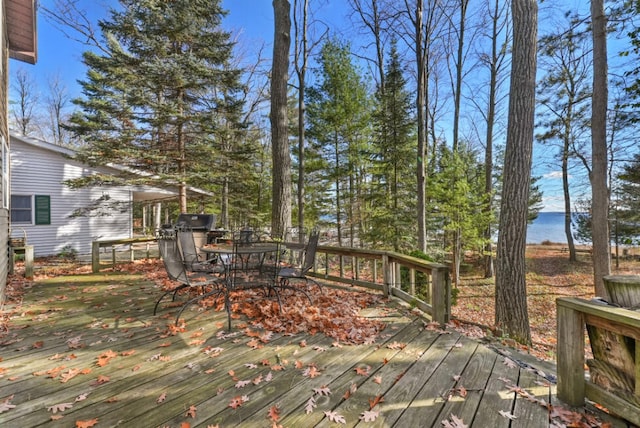 wooden deck featuring outdoor dining area and a water view