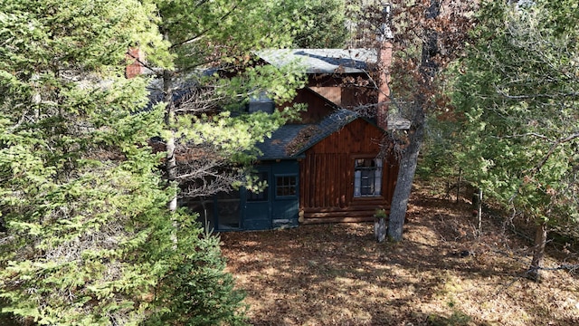 view of side of property featuring a shingled roof