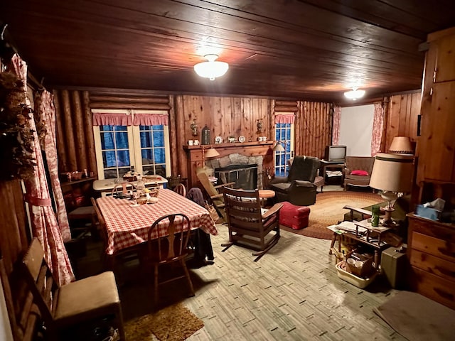 interior space featuring a stone fireplace, wood ceiling, wooden walls, and wood finished floors