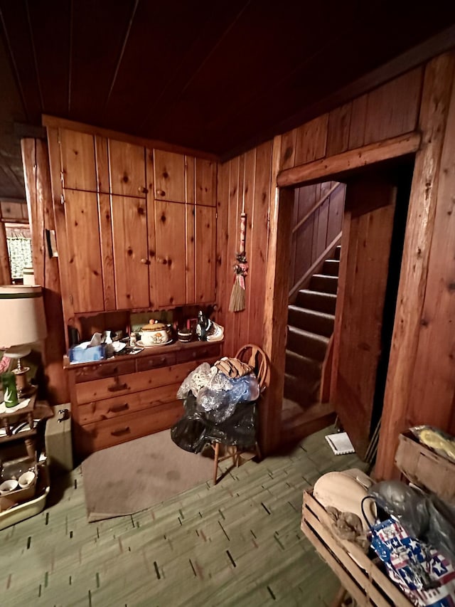 miscellaneous room featuring stairway, wood finished floors, and wood walls