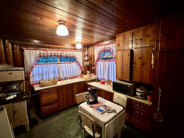 kitchen with wooden ceiling, brown cabinetry, dark colored carpet, and black microwave