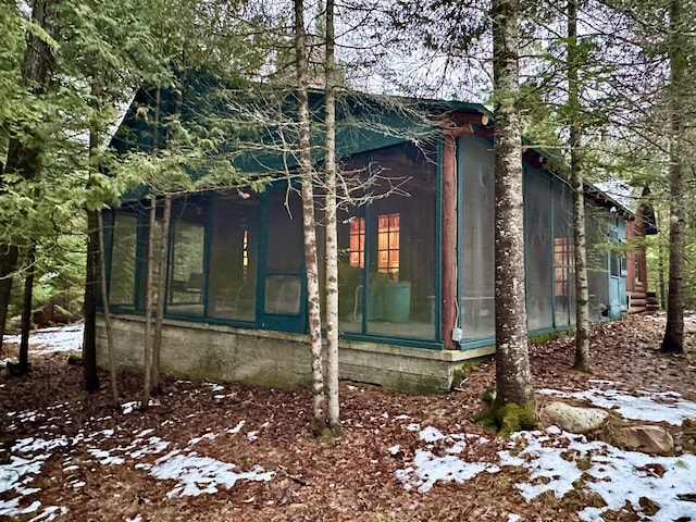 snow covered property with a sunroom