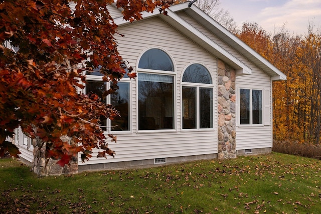 view of side of home with a yard and crawl space