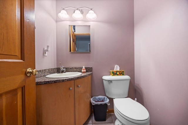 half bathroom featuring vanity, tile patterned floors, toilet, and baseboards