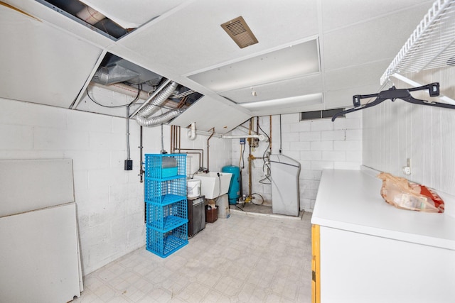 unfinished below grade area with visible vents, a sink, freestanding refrigerator, white refrigerator, and light floors