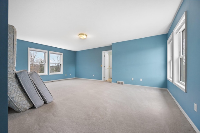 carpeted empty room with baseboards and visible vents