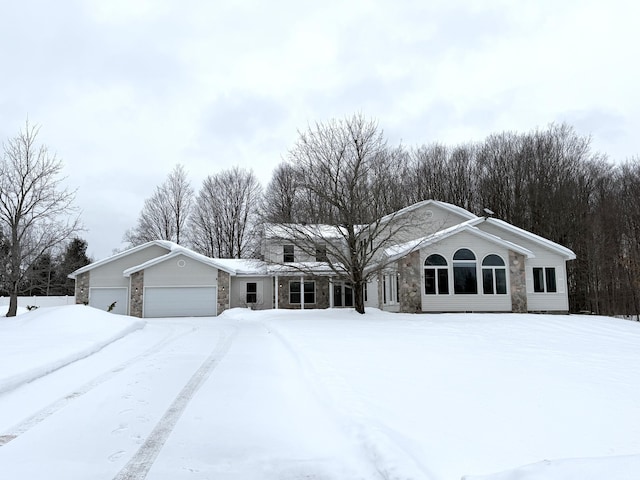 ranch-style home with a garage and stone siding