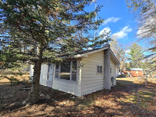 view of side of property with an outdoor structure and a chimney