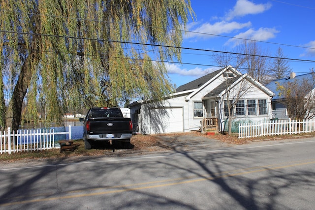 view of front of home featuring aphalt driveway, a garage, and a fenced front yard