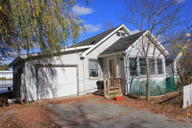 view of front of property featuring an attached garage, fence, and driveway