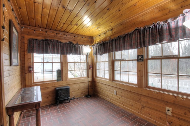 unfurnished sunroom with wooden ceiling and a wood stove