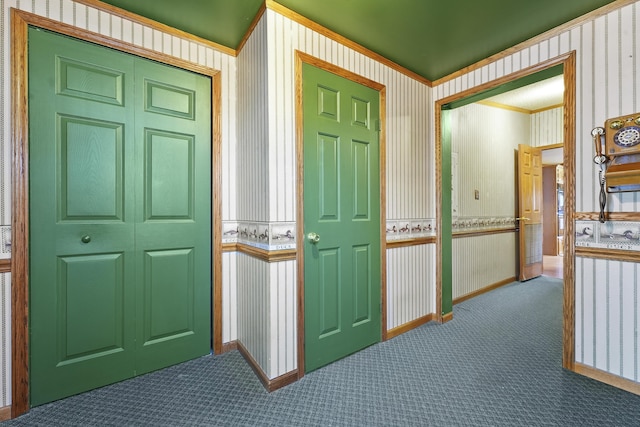 interior space featuring wallpapered walls, crown molding, baseboards, and carpet floors