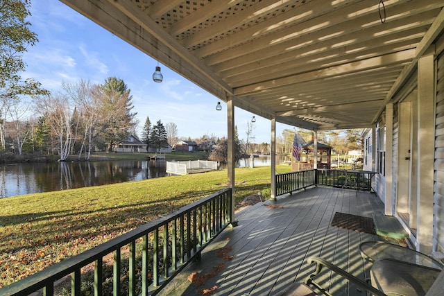 wooden deck with a yard and a water view