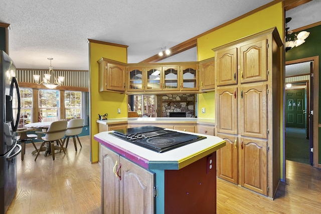 kitchen with black appliances, a textured ceiling, light wood finished floors, a chandelier, and light countertops