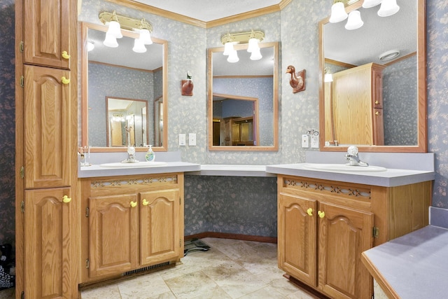 bathroom featuring wallpapered walls, crown molding, two vanities, and a sink