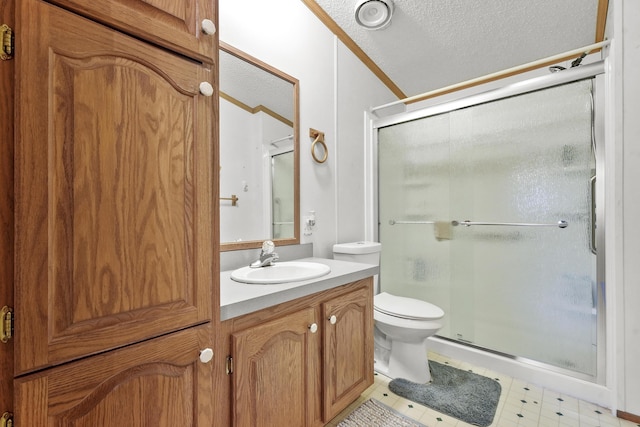 bathroom featuring a shower stall, crown molding, toilet, vanity, and a textured ceiling