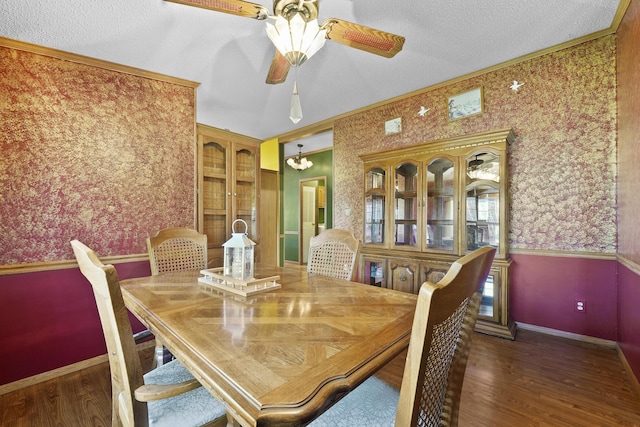 dining space with wallpapered walls, crown molding, and wood finished floors