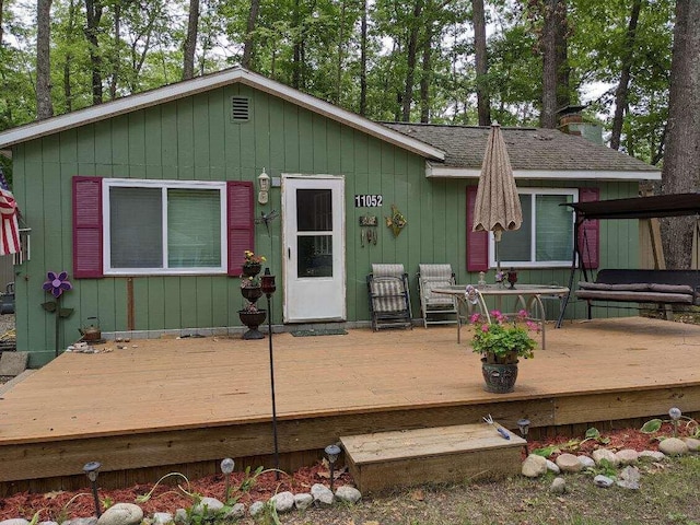 back of house with a wooden deck and a shingled roof