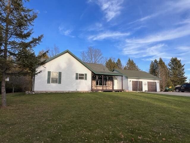 ranch-style house with a front lawn, a garage, and driveway