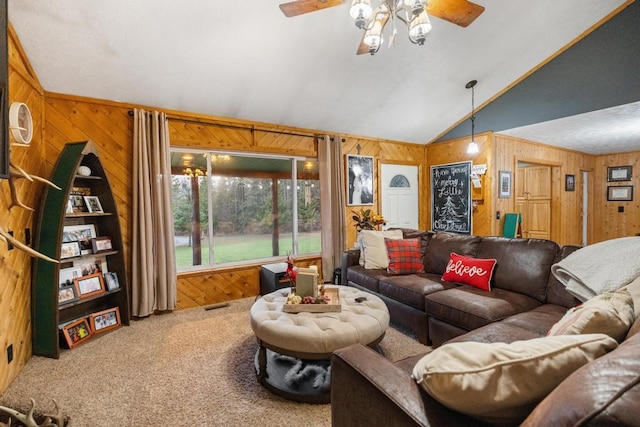 carpeted living room featuring visible vents, wooden walls, ceiling fan, and vaulted ceiling