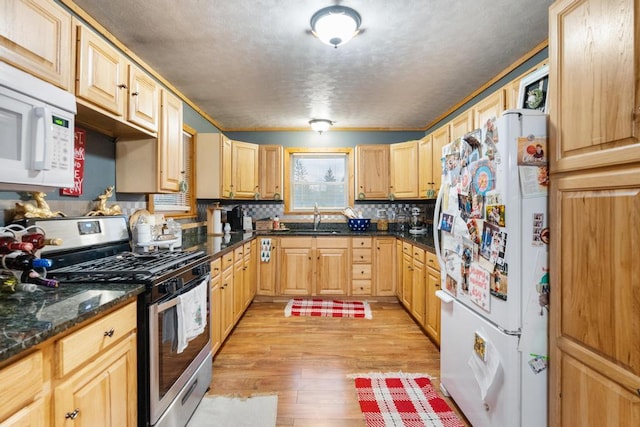 kitchen featuring light wood-type flooring, light brown cabinets, a sink, backsplash, and white appliances