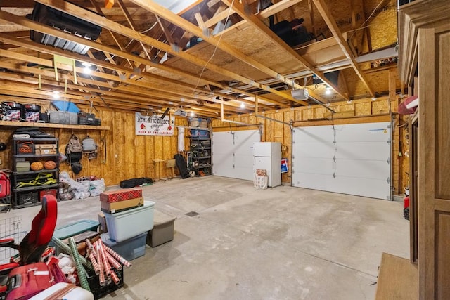 garage with a garage door opener and freestanding refrigerator