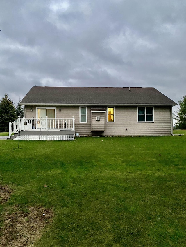 back of house featuring a lawn and a deck