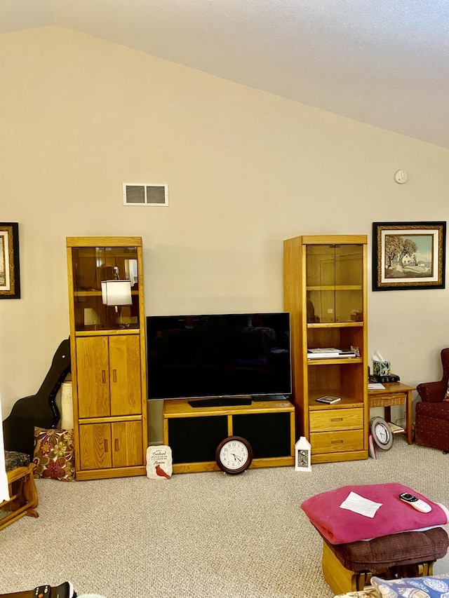 living area featuring vaulted ceiling, carpet, and visible vents