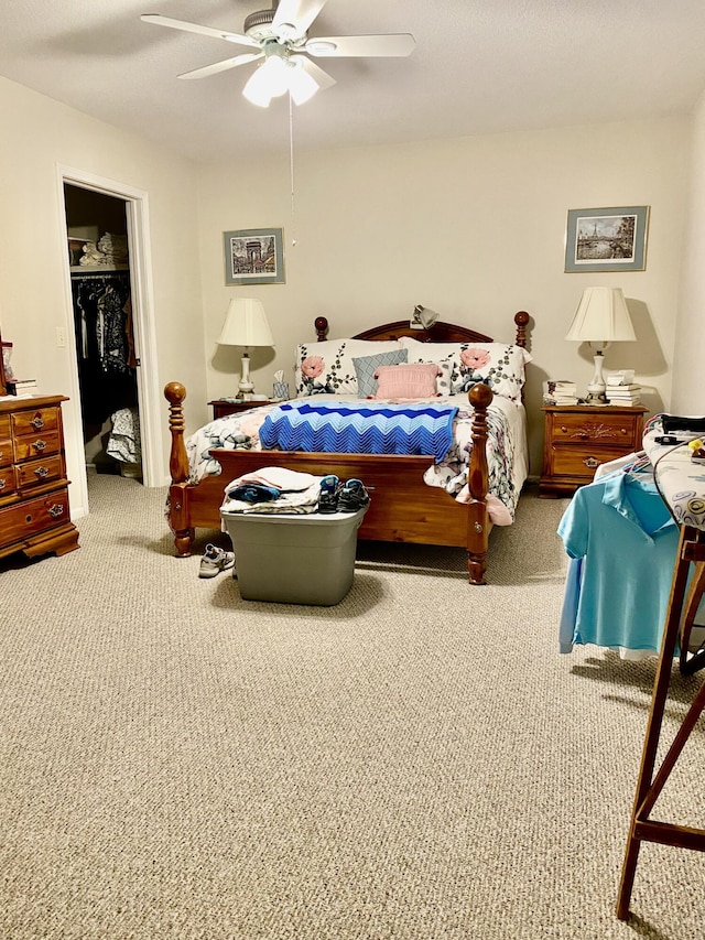 bedroom with a closet, carpet floors, a spacious closet, and a ceiling fan