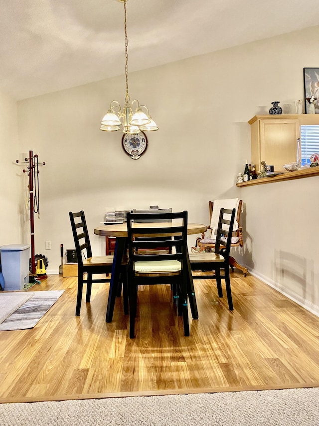 dining room featuring an inviting chandelier, wood finished floors, and baseboards