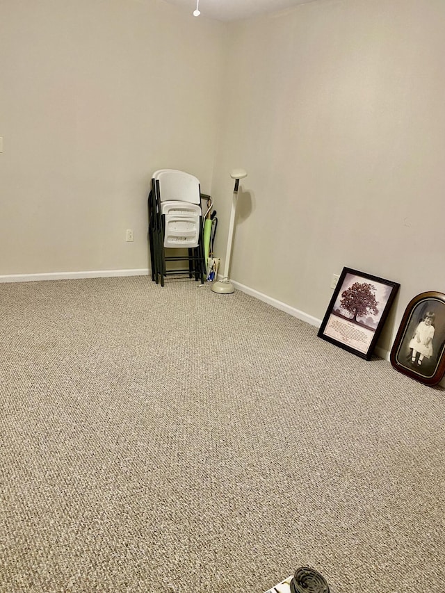 unfurnished room with carpet flooring and baseboards