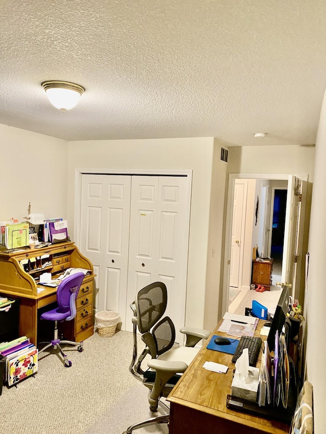 carpeted office with visible vents and a textured ceiling