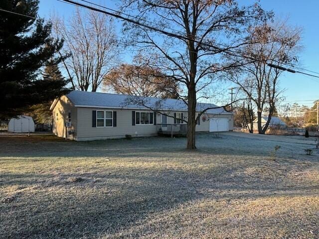 ranch-style home with a garage, a front lawn, and driveway