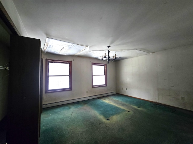 carpeted spare room featuring a baseboard heating unit and an inviting chandelier