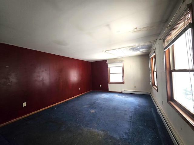 empty room featuring a baseboard heating unit and baseboards