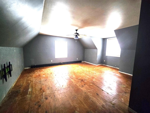 bonus room featuring hardwood / wood-style floors, a ceiling fan, baseboards, lofted ceiling, and a baseboard heating unit