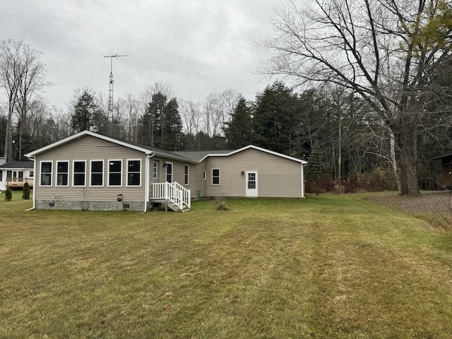 rear view of property with crawl space and a lawn