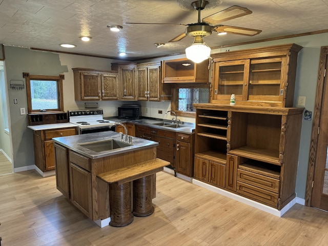 kitchen featuring white electric stove, open shelves, an island with sink, a sink, and black microwave