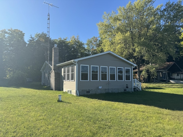 rear view of property with a yard, a chimney, and crawl space