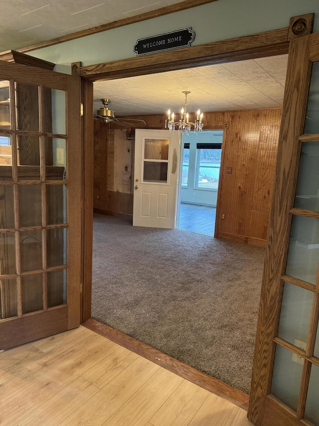 interior space featuring an inviting chandelier, wood finished floors, and wood walls