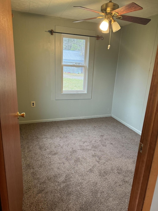 carpeted spare room with baseboards and ceiling fan