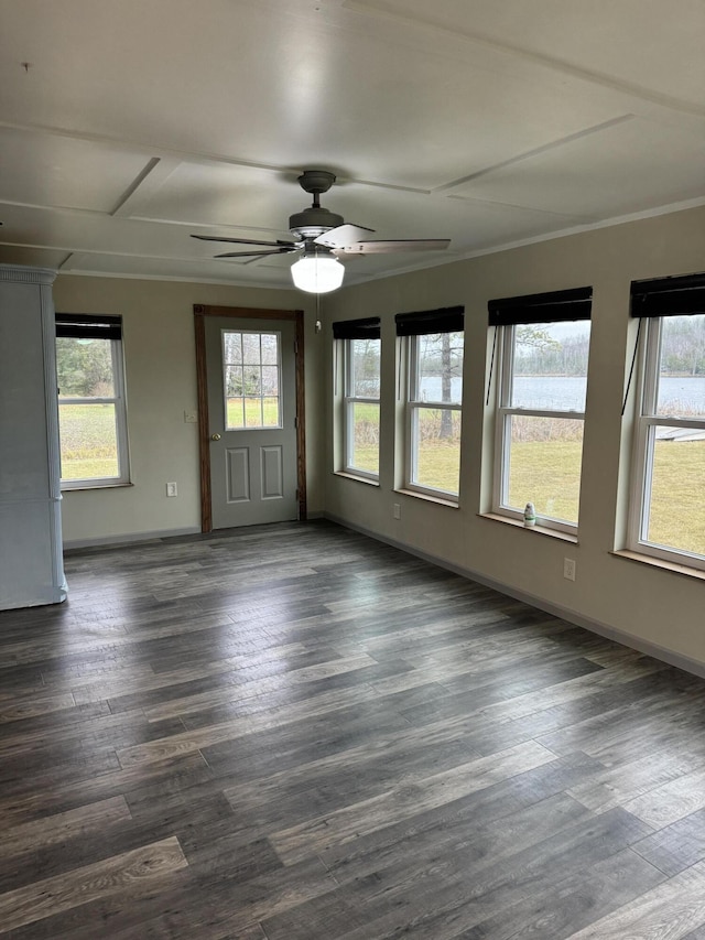 spare room featuring a ceiling fan, baseboards, dark wood-style flooring, and ornamental molding