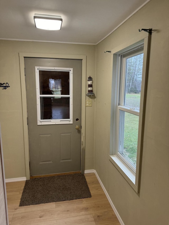 doorway featuring light wood finished floors and baseboards