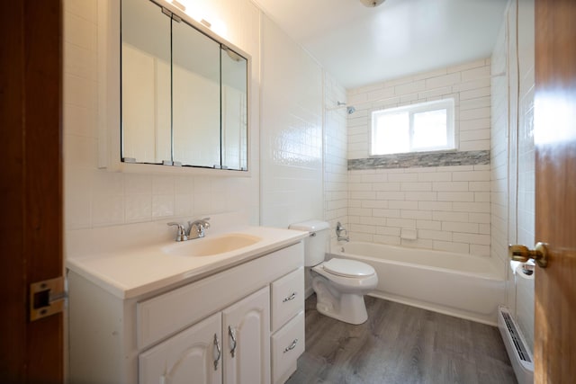 full bathroom featuring vanity, wood finished floors,  shower combination, a baseboard heating unit, and toilet