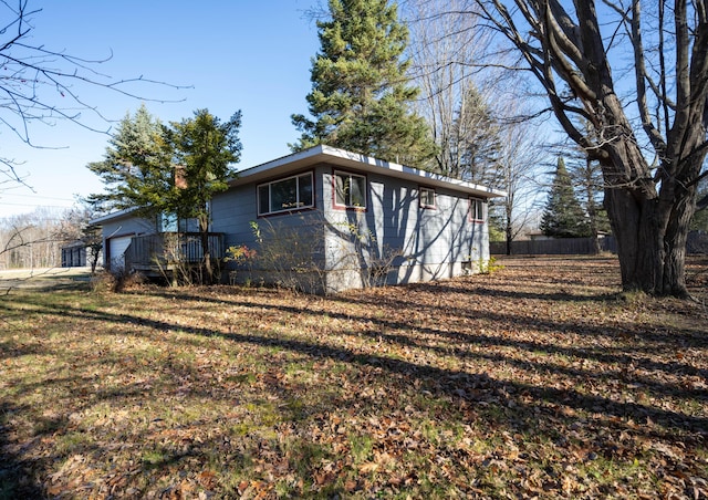 view of side of property with a lawn and fence