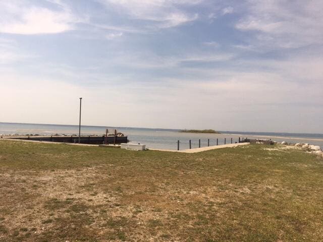 dock area featuring a lawn and a water view